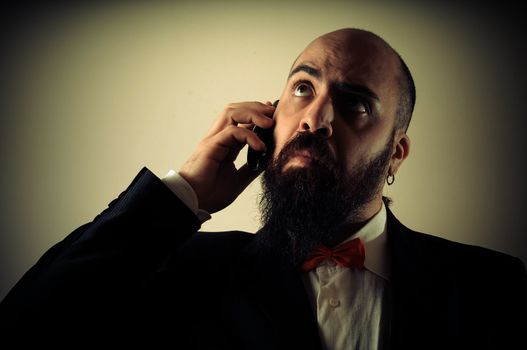  funny elegant bearded man on the phone on vignetting background
