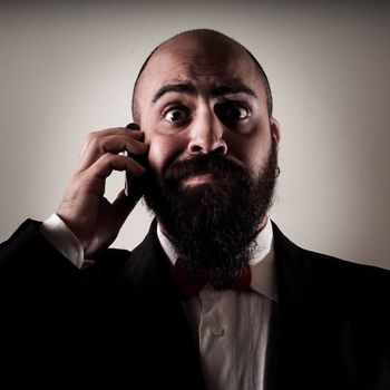  funny elegant bearded man on the phone on vignetting background
