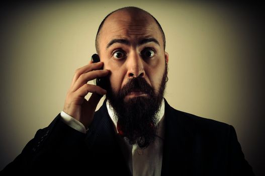 funny elegant bearded man on the phone on vignetting background