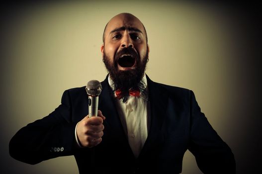  funny elegant singer bearded on vignetting background