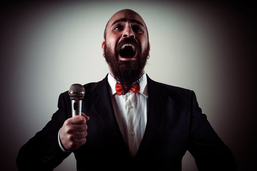  funny elegant singer bearded on vignetting background