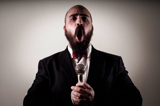  funny elegant singer bearded on vignetting background