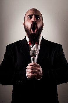  funny elegant singer bearded on vignetting background