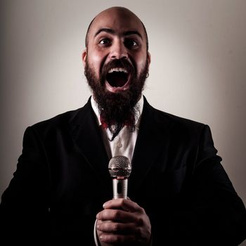  funny elegant singer bearded on vignetting background