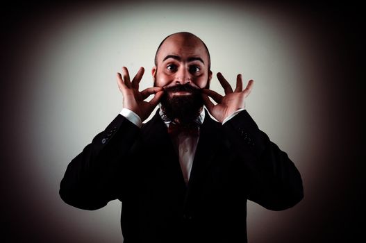  funny elegant bearded man touching mustache on vignetting background