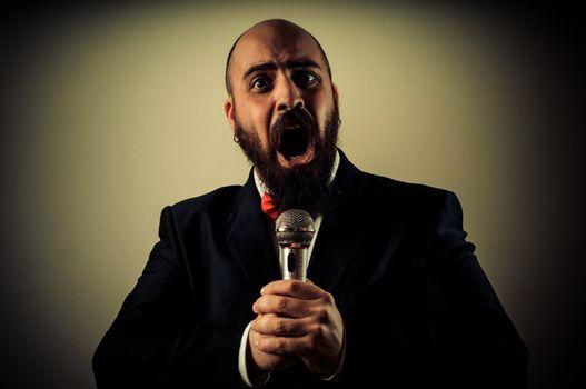  funny elegant singer bearded on vignetting background