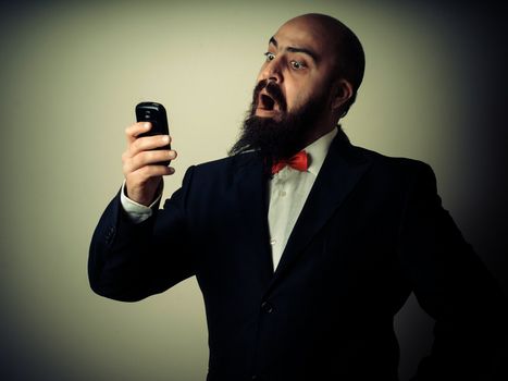  funny elegant bearded man on the phone on vignetting background
