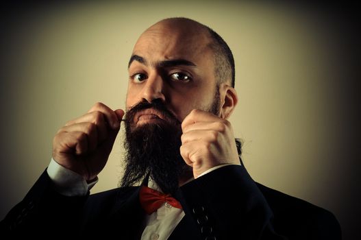  funny elegant bearded man touching mustache on vignetting background