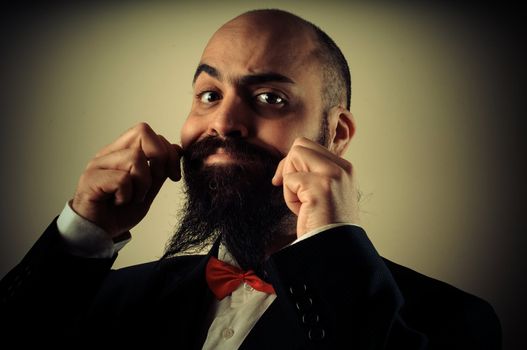  funny elegant bearded man touching mustache on vignetting background