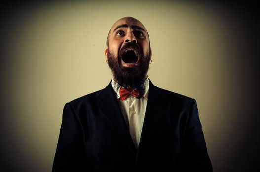 funny afraid elegant bearded man on vignetting background