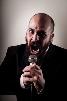  funny elegant singer bearded on vignetting background