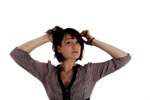 portrait of a young woman in grey dress playing with her hair on studio