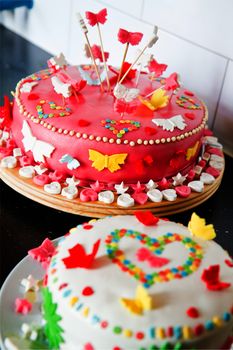 Colorful decorated white and pink Marzipan cakes for a birthday party on kitchen dresser