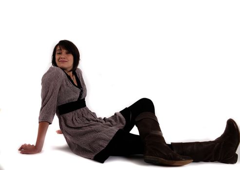 young brunette woman in dress sitting on the ground with boots