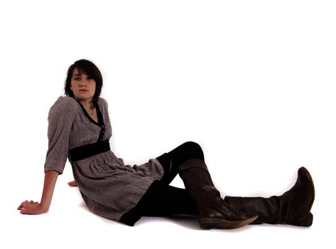 young brunette woman in dress sitting on the ground with boots