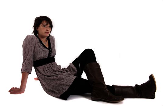 young brunette woman in dress sitting on the ground with boots