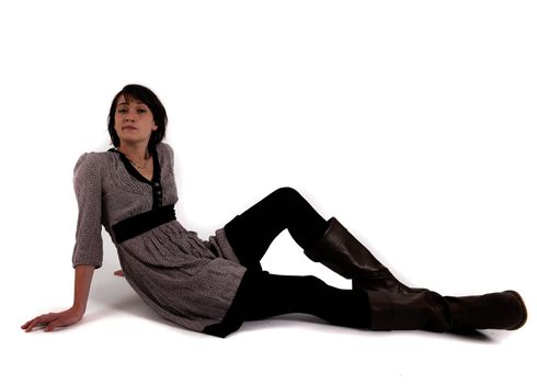 young brunette woman in dress sitting on the ground with boots