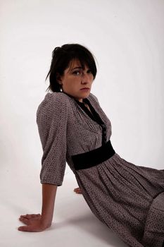 young brunette woman in dress sitting on the ground with boots