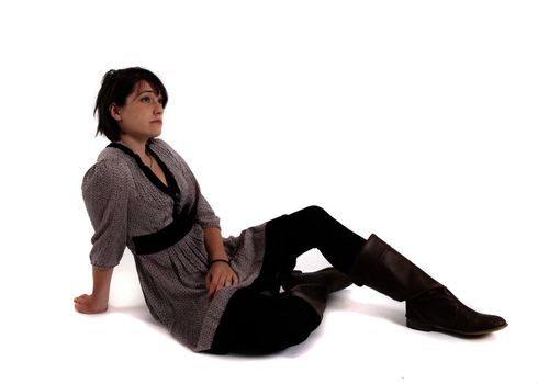young brunette woman in dress sitting on the ground with boots