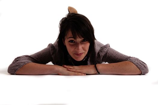 young brunette woman lenthened on the ground isolated in studio looking ahead