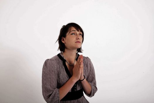 portrait of a young brunette woman requesting in catholic posture united hand