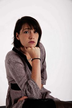 young woman looking ahead with hand under her face isolated in studio