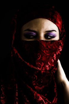 Arab young with traditional red veil, eyes intense, mystical beauty