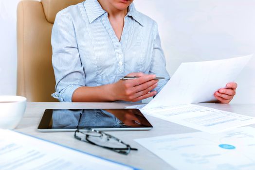 Busy businesswoman wearing in casual shirt sitting at desk and check documents in the office