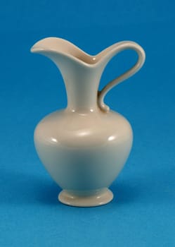 cute shape white ceramic pitcher jug jar on blue background.