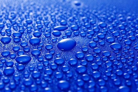 Water droplets on a blue metal background