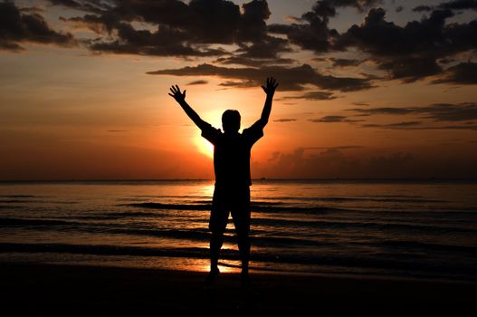 silhouette of feel free and happy man on the beach