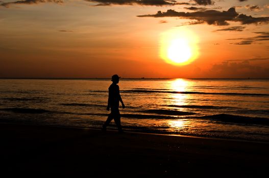 silhouette woman walking on the beach