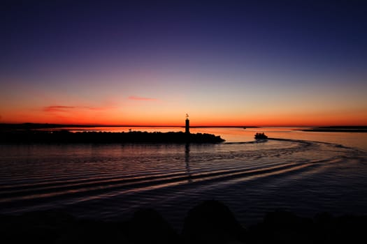 Beautiful view of the departure of a fishing boat in the early morning in Fuzeta, Portugal.