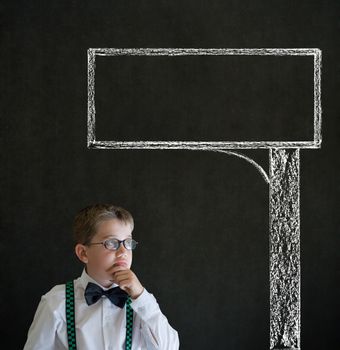 Thinking boy dressed up as business man with chalk road advertising sign on blackboard background