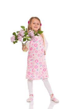 Smiling little girl with long hair wearing summer dress standing and holding lilac flowers. Isolated on white background.