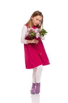 Pretty young girl with long hair wearing red dress and holding lilac flowers. Isolated on white background.