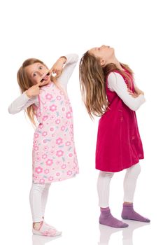 Two funny children with long hair making faces. Isolated on white background.