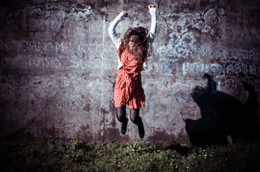 happy eastern vintage hipster woman jumping in the park
