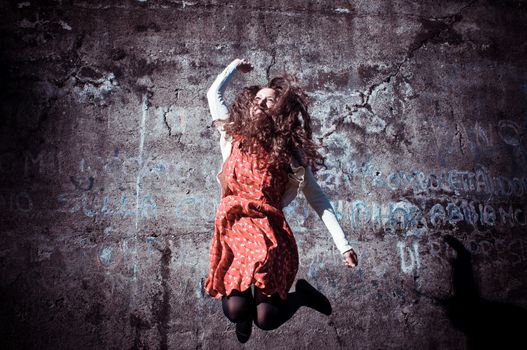 happy eastern vintage hipster woman jumping in the park