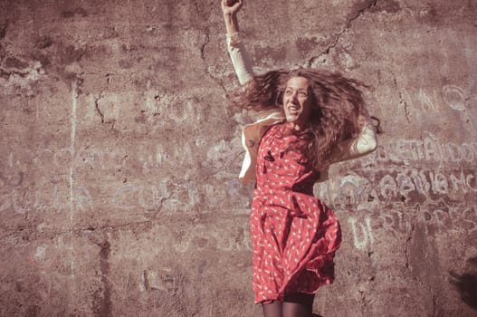 happy eastern vintage hipster woman jumping in the park
