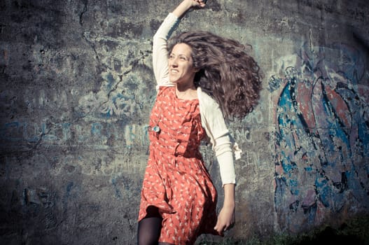 happy eastern vintage hipster woman jumping in the park