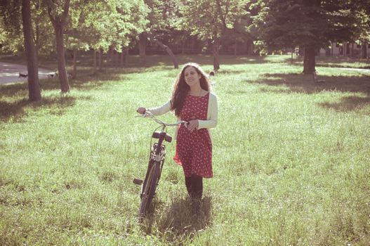 vintage eastern hipster woman with bike in the park