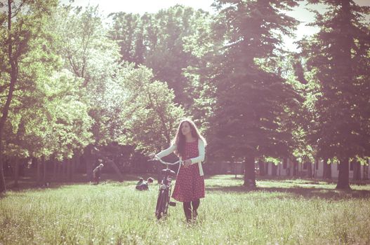 vintage eastern hipster woman with bike in the park
