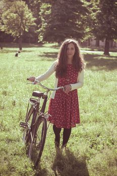 vintage eastern hipster woman with bike in the park