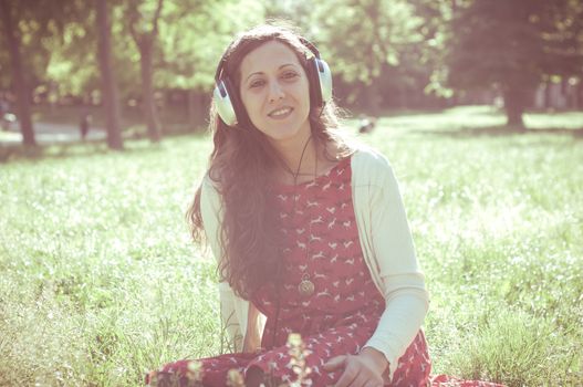 vintage hipster eastern woman with headphones in the park