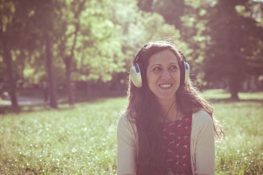 vintage hipster eastern woman with headphones in the park