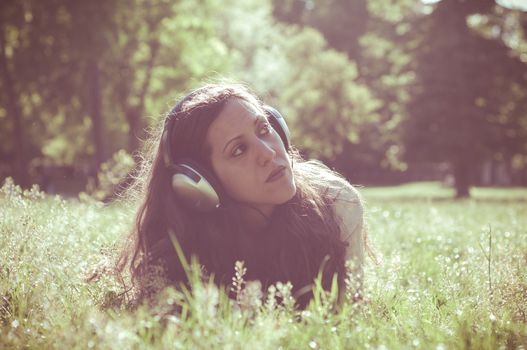 vintage hipster eastern woman with headphones in the park