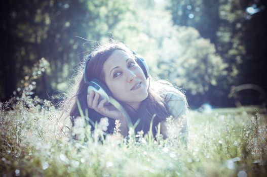 vintage hipster eastern woman with headphones in the park