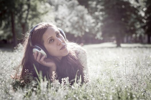 vintage hipster eastern woman with headphones in the park
