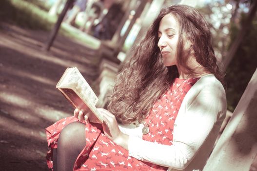 eastern hipster vintage woman reading book in the park
